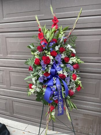 A large bouquet of flowers hanging on the side of a garage door.