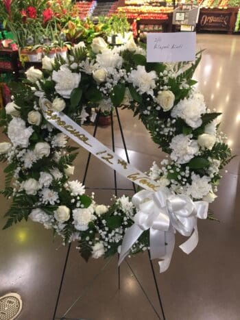 A wreath of white flowers on display in a room.