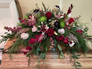 A table with flowers and greenery on it.