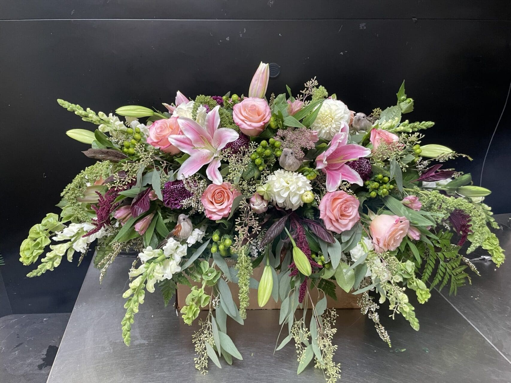 Pink and white floral arrangement with birds.